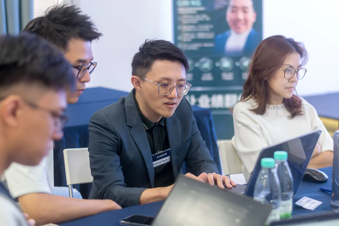 Patrick Teoh coaching a participant at a laptop during a hands on AI workshop