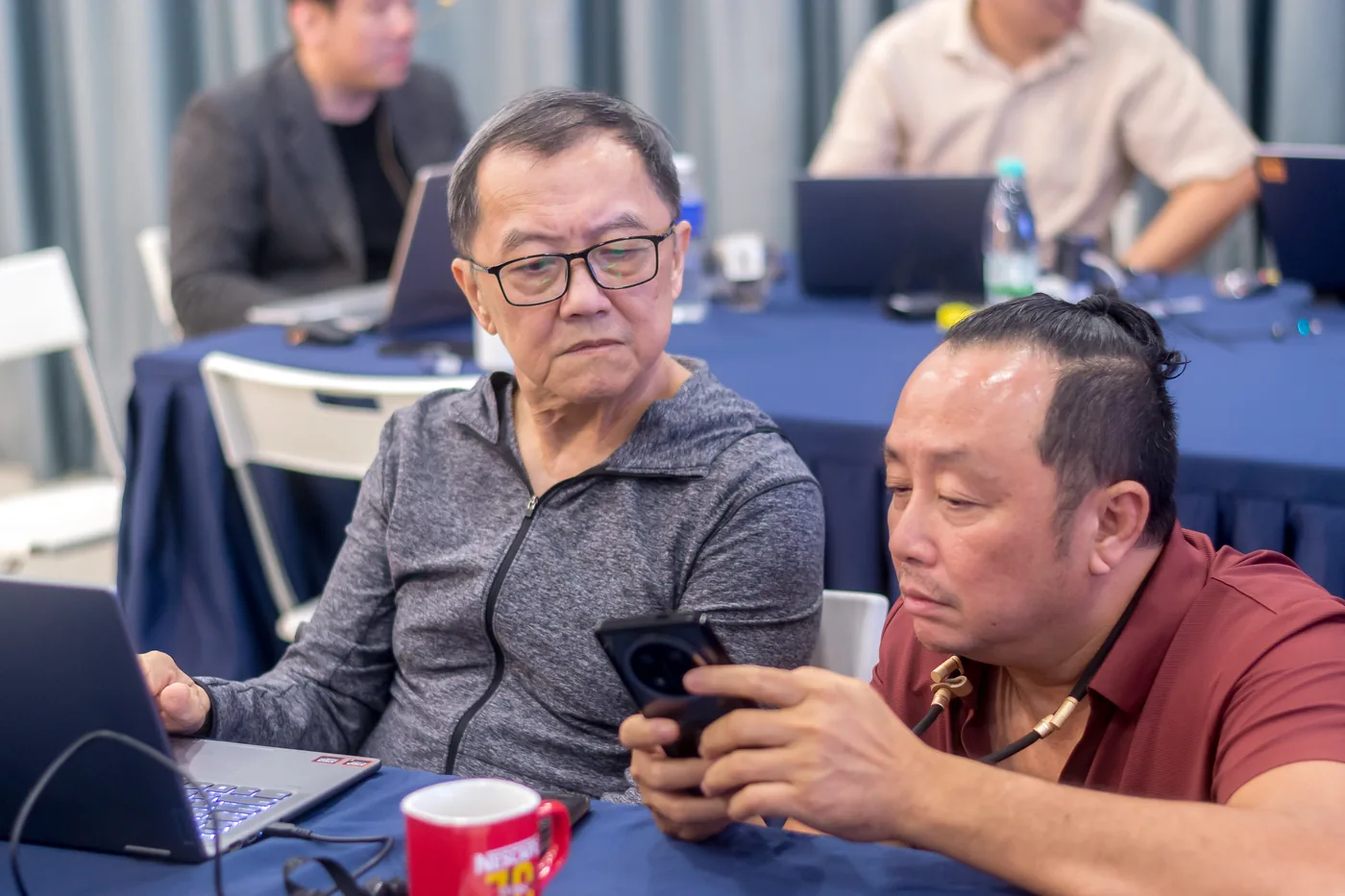 Two business owners working through an AI task together on a laptop